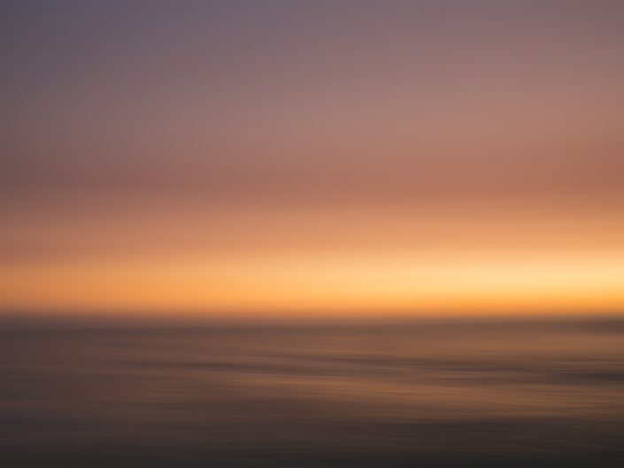 panning abstract of the coastline water and sky at sunset
